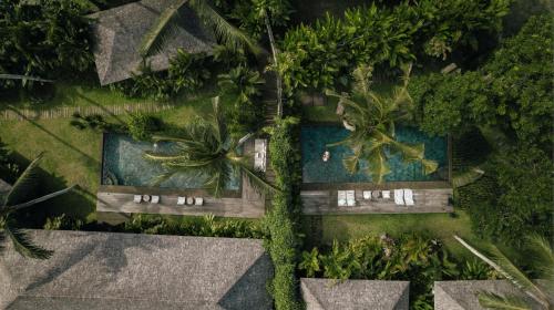 an overhead view of a resort with two pools and palm trees at Bedulu Cliff Estate Villas Complex Ubud in Ubud