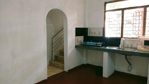 a kitchen with a sink and a window and a counter at Dini's home stay in Matara