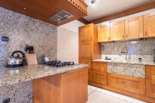 a kitchen with wooden cabinets and granite counter tops at Apartamenty w Gorcach in Nowy Targ
