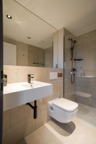 a bathroom with a sink and a toilet and a shower at Limehome Saarbrücken Berliner Promenade in Saarbrücken