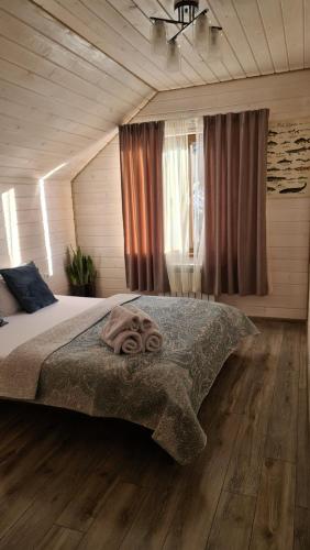 a bedroom with a large bed and a wooden floor at Villa Debryanets in Rozhanka Nizhnyaya