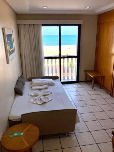 a bedroom with a bed with a view of the ocean at Hotel Flat Classic in Fortaleza