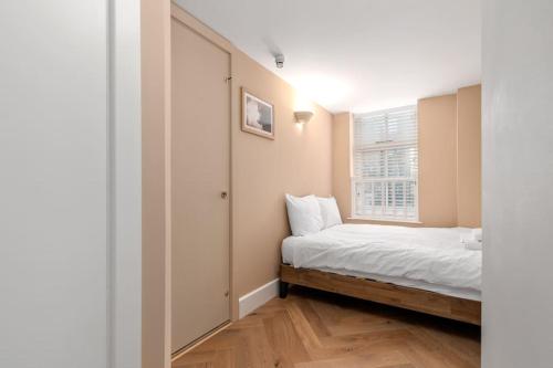 a small bedroom with a bed and a window at GuestReady - Beige barley near museum in London