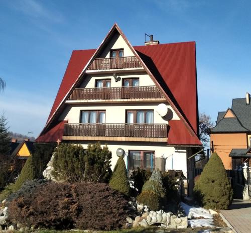 una gran casa blanca con techo rojo en Dom na Brzyzku en Poronin