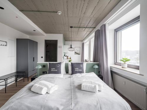 a bedroom with a large white bed with two pillows at Limehome Saarbrücken Berliner Promenade in Saarbrücken