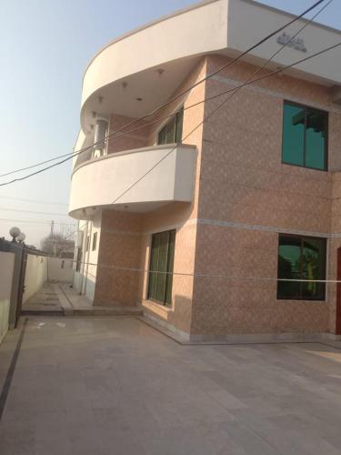 un edificio con un balcón en el lateral. en Impeccable 4-Bed Villa in Mirpur azad khasmir, en Pothi