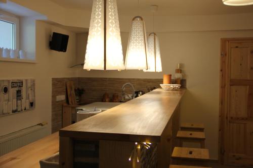a kitchen with two chandeliers and a counter top at Apartmány Mamut Harrachov in Harrachov
