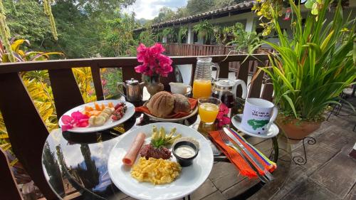 een tafel met borden ontbijtproducten op een balkon bij Garden Hotel in Copan Ruinas