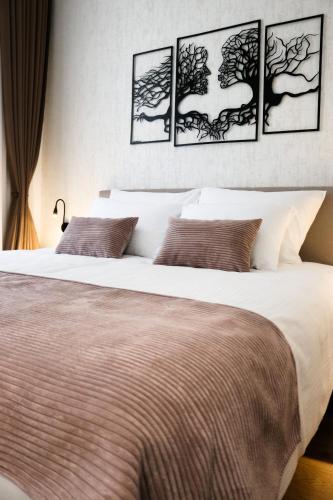 a bedroom with a large bed with four pictures on the wall at Sarajevo CODE in Sarajevo