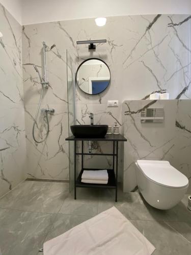 a bathroom with a sink and a toilet and a mirror at Guest House Penzión Fortuna in Tvrdošín