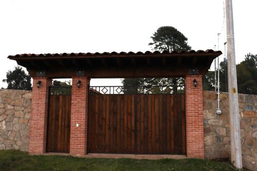 een houten hek met een houten hek bij Casa Aralias in Zacatlán