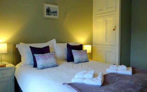 a bedroom with a large white bed with towels on it at Cherry Cottage, Youlgrave Nr Bakewell in Youlgreave