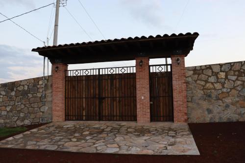 een poort in een stenen muur met een houten poort bij Casa Aralias in Zacatlán