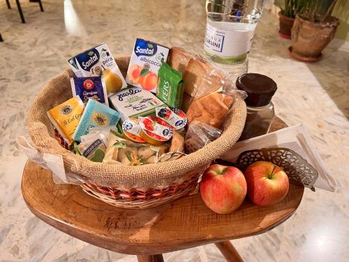ein Korb mit Lebensmitteln und Äpfeln auf einem Tisch in der Unterkunft B&B Leggieri Villa Siria in San Giovanni Rotondo