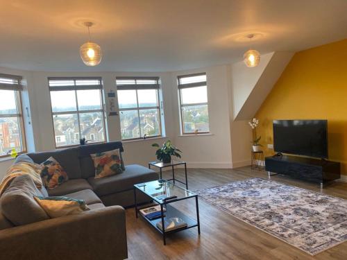 a living room with a couch and a flat screen tv at The Retreat in Weston-super-Mare