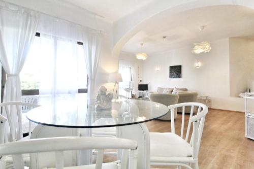 a dining room with a glass table and white chairs at T2 Holiday Cottage near the beach C225 in Porches