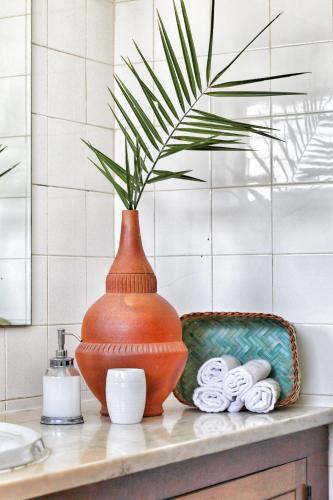 an orange vase sitting on a counter with a plant at T2 Holiday Cottage near the beach C225 in Porches