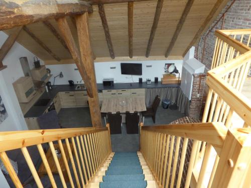 an overhead view of a kitchen and living room with wooden stairs at Ferienwohnung Gulf im Gulfhof am Kanal in Großefehn 