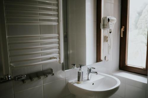 a white bathroom with a sink and a phone at Villa Garden in Oleśnica