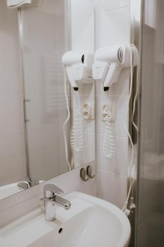 a white bathroom with a sink and a mirror at Villa Garden in Oleśnica