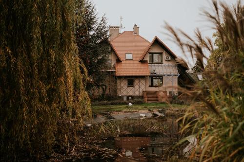 an old house with a pond in front of it at Villa Garden in Oleśnica