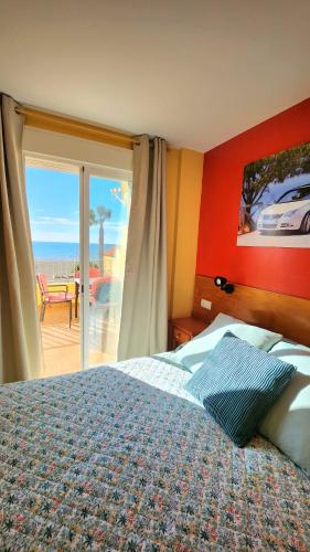 a bedroom with a bed and a view of the ocean at HOSTAL LA ESTACION in Benajarafe