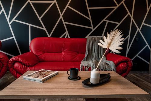 Augšlīgatne的住宿－Alejas apartamenti，客厅配有红色的沙发和桌子