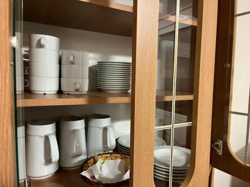 a cabinet with plates and cups and dishes in it at HOTEL Kuruc Panzio TARPA Kossuth utca 25E 