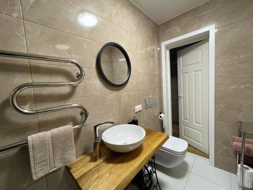 a bathroom with a sink and a toilet and a mirror at Südalinna apartment in Kuressaare