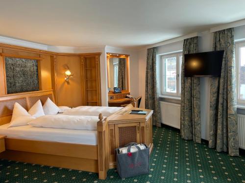 a hotel room with a bed and a television at Wohlfühlhotel Berwanger Hof in Obermaiselstein