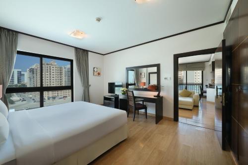 a hotel room with a bed and a desk and a room at Park Apartments Dubai, an Edge By Rotana Hotel in Dubai