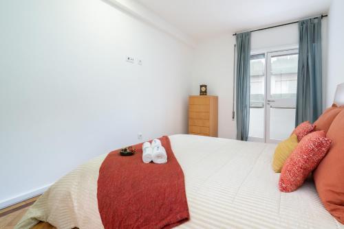a bedroom with a bed with slippers on it at Host Wise - Spacious Fresh Flat w Terrace - Near Sea in Espinho