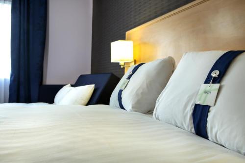 a hotel room with two beds with white pillows at Holiday Inn Express Manchester Airport by IHG in Hale