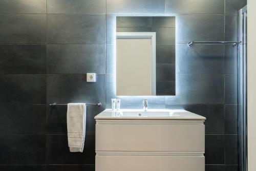 a bathroom with a white sink and a mirror at Host Wise - Spacious Fresh Flat w Terrace - Near Sea in Espinho