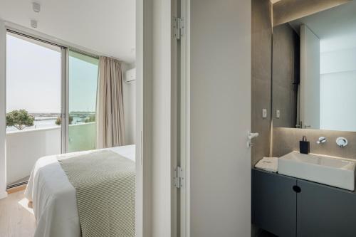 bagno con letto, lavandino e specchio di Lapa 84-A - seafront house a Póvoa de Varzim
