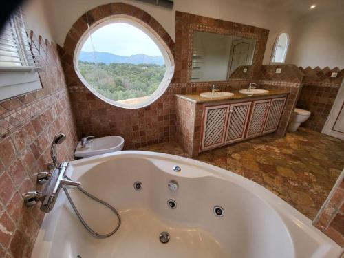 a large bathroom with a tub and a round window at Casa Marcelli 5 in Porto-Vecchio