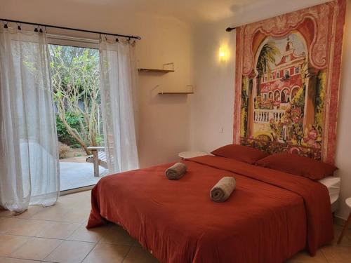 a bedroom with a red bed and a large window at Casa Marcelli 5 in Porto-Vecchio