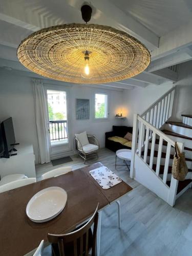 d'un salon avec une table à manger et un lustre. dans l'établissement Appartement lumineux Capbreton, à Capbreton