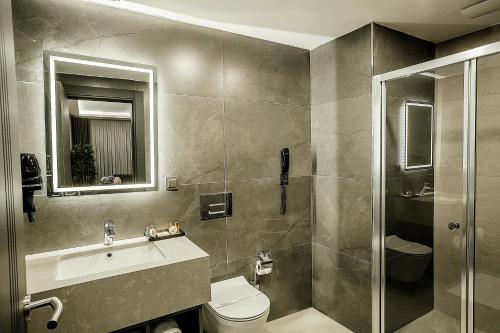 y baño con aseo, lavabo y ducha. en Kızılkaya Business Otel, en Korfez