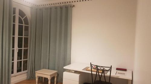 une pièce avec une table, une chaise et une fenêtre dans l'établissement Chambre Ricardo, à Orsay