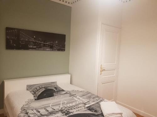1 dormitorio con 1 cama con una foto en la pared en Chambre Ricardo en Orsay