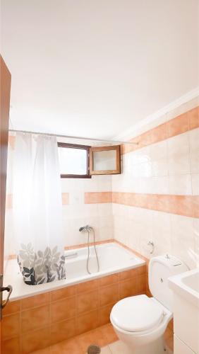 a bathroom with a tub and a toilet and a sink at Casa Chara 2 in Symi