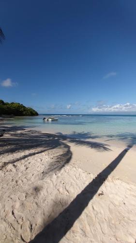 a long shadow of a person on a beach at Le cottage du Littoral de Petit Havre in Le Gosier