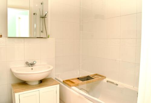a bathroom with a sink and a toilet and a tub at Beautiful 1-Bed Apartment in Redhill in Redhill