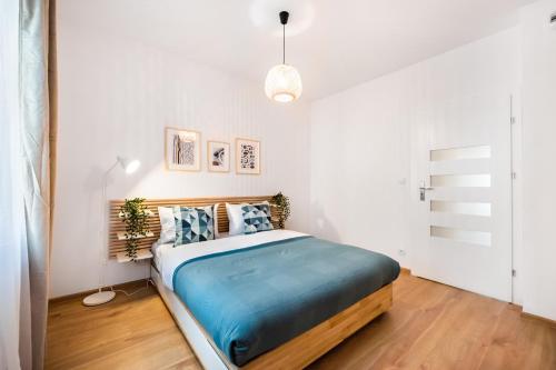 um quarto com uma cama num quarto branco em Mokotów Passion Apartment em Varsóvia