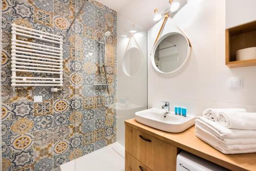 a bathroom with a sink and a mirror at Mokotów Passion Apartment in Warsaw