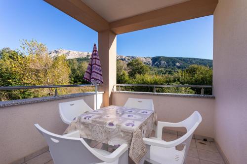 a table and chairs on a balcony with a view at Apartments Crnekovic Jasna in Baška