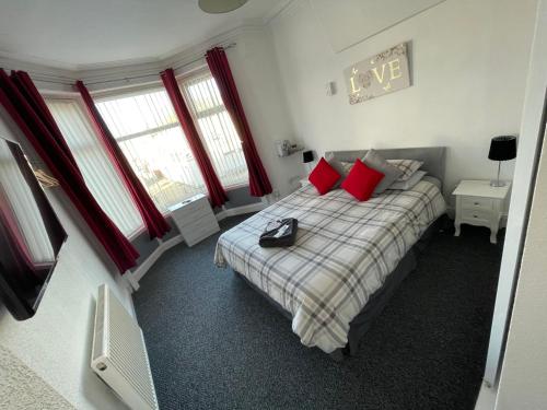 sypialnia z łóżkiem z czerwonymi poduszkami w obiekcie Harleys Reads Avenue w Blackpool