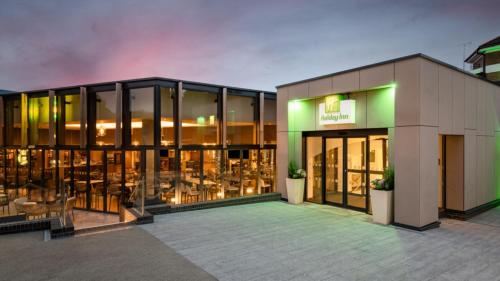 a building with a lot of windows and tables at Holiday Inn London Gatwick - Worth, an IHG Hotel in Crawley