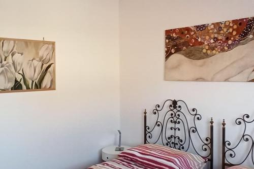 1 dormitorio con 1 cama y una pintura en la pared en Casa vacanze Donna Michela, en Ponzano Veneto